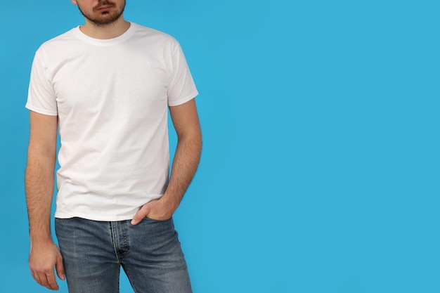 Free photo a young guy in a white tshirt on a blue background