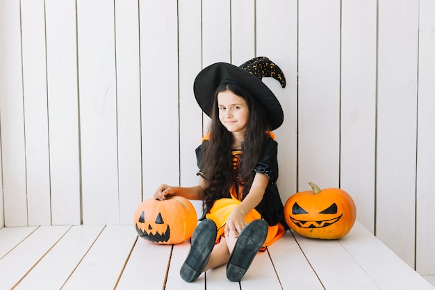 Free Photo young halloween witch and jack-o-lanterns