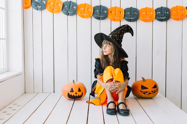 Free Photo young halloween witch starring at window