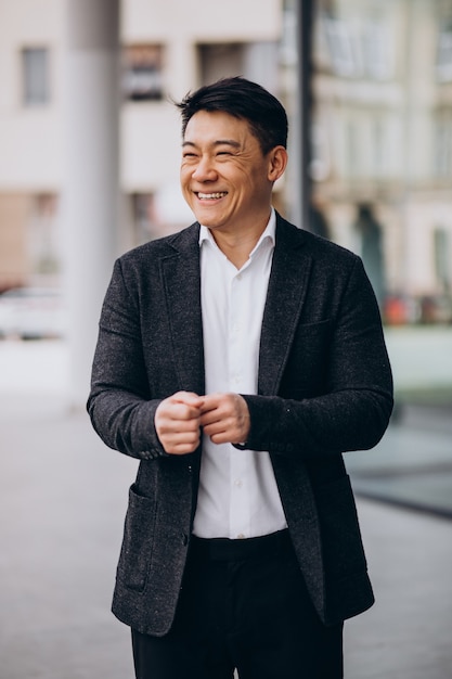 Free photo young handsome asian business man in black suit