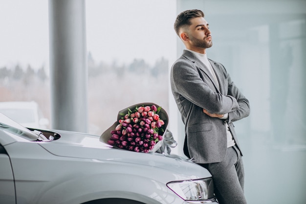 Free photo young handsome business man delivering bouquet of beautiful flowers