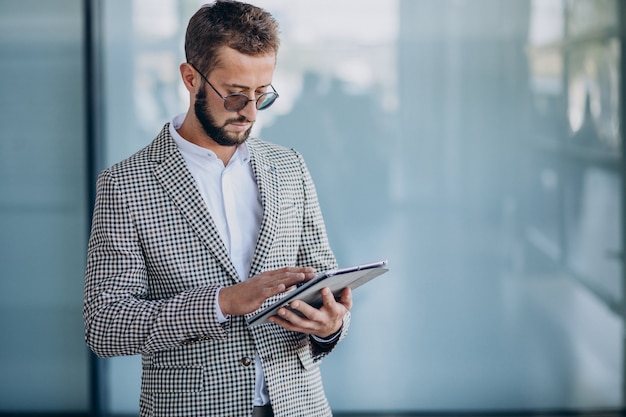 Free photo young handsome business man in office holding tablet