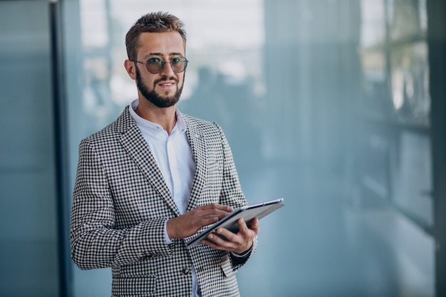 Free photo young handsome business man in office holding tablet