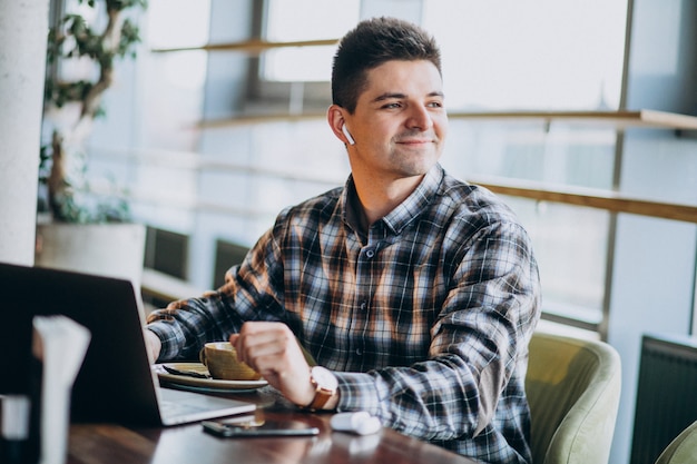 Young handsome business man using laptop in a cafe