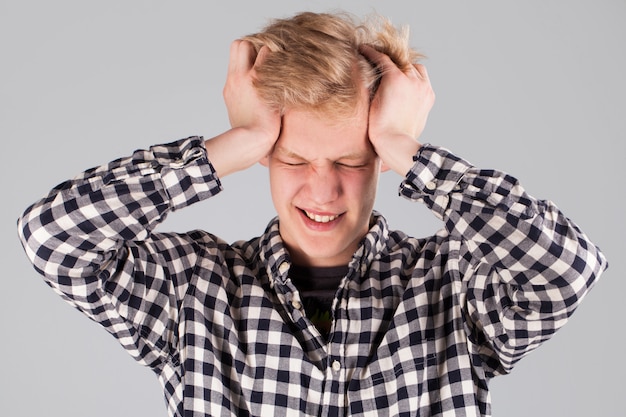 Young handsome guy with hand on head