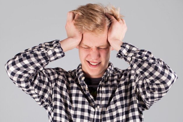 Young handsome guy with hand on head