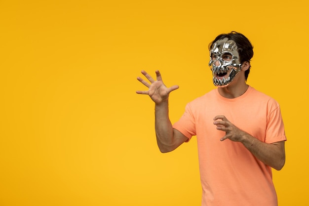 Young handsome male with scary golden mask yellow background cartoon