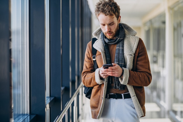 Young handsome man at airport talking on the phone