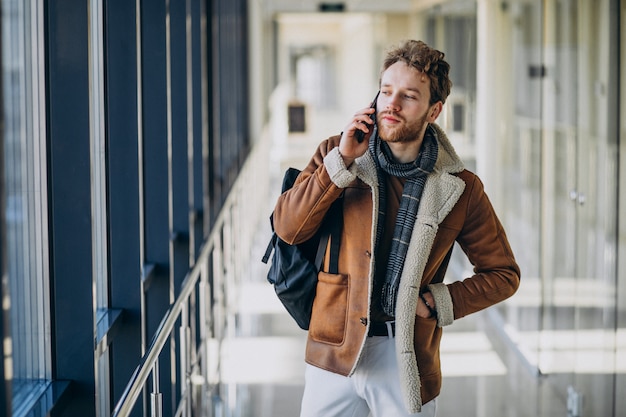 Young handsome man at airport talking on the phone