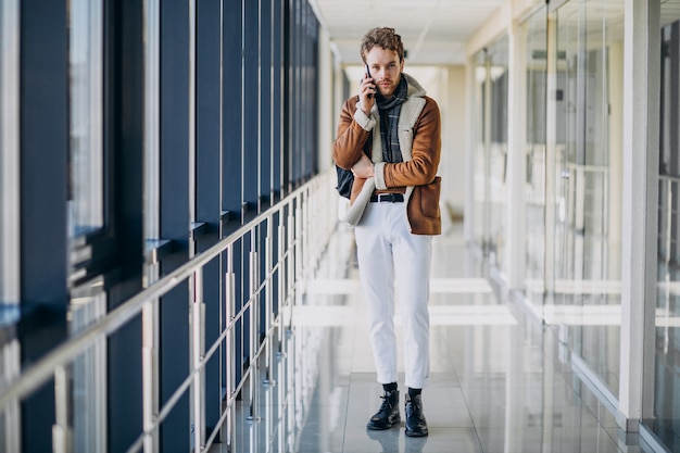 Free photo young handsome man at airport talking on the phone