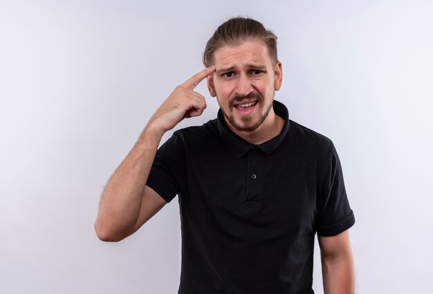 Young handsome man in black polo shirt looking worried and confused pointing temple standing over white background