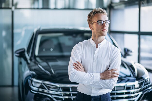 Young handsome man in a car showroom