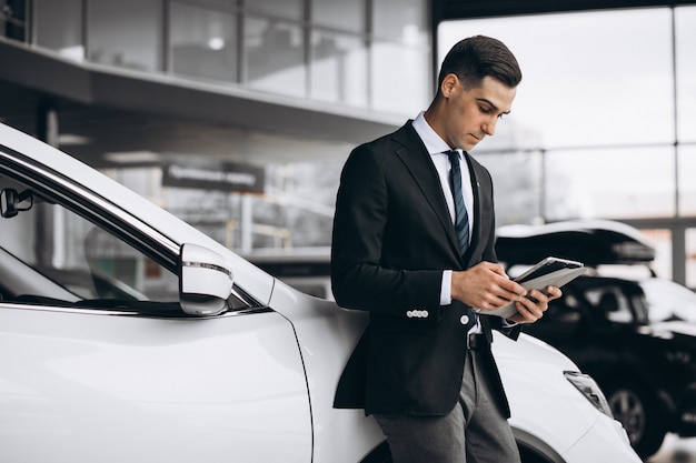 Young handsome man in car showroom