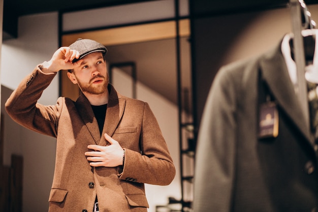 Free Photo young handsome man choosing hat at the shop