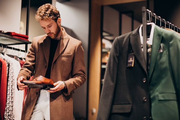 Free Photo young handsome man choosing shoes at a shop