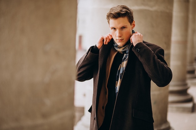 Free Photo young handsome man in a coat outside the street