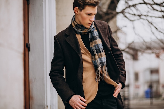 Young handsome man in a coat outside the street