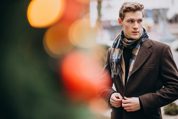 Young handsome man in a coat outside the street