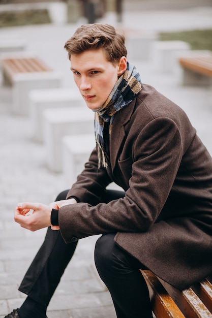 Young handsome man in a coat outside the street