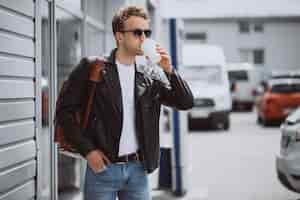 Free photo young handsome man drinking coffee in the street