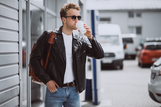 Free Photo young handsome man drinking coffee in the street