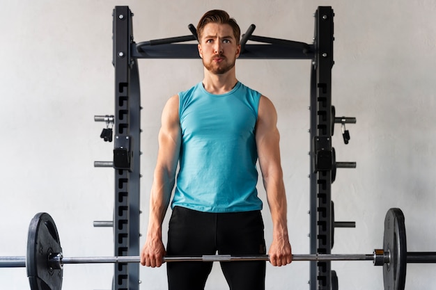 Young handsome man exercising at the gym for bodybuilding