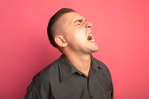 Free Photo young handsome man in grey shirt shouting with aggressive expression being annoyed 