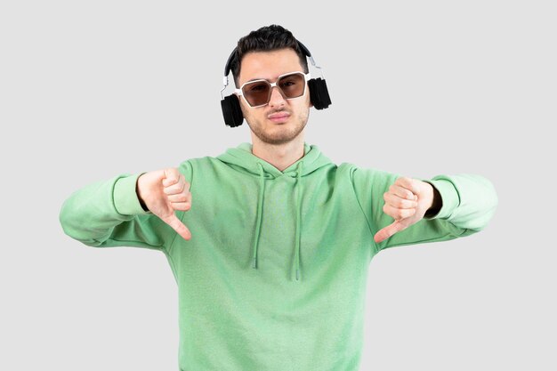 young handsome man in headphones giving thumbs down