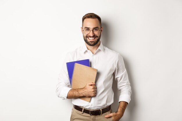 Young handsome man holding notebooks, concept of e-learning and courses.