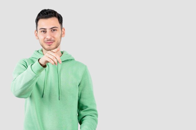 young handsome man in hoodie standing and posing