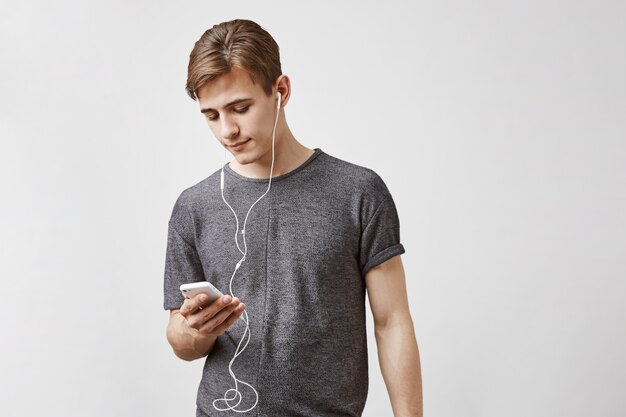 Free Photo young handsome man listens music in smartphone.