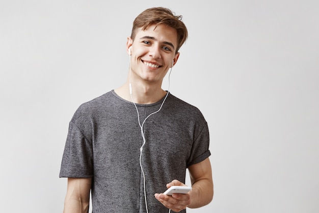 Young handsome man listens music in smartphone.