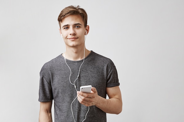 Young handsome man listens music with earphones