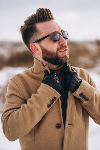 Young handsome man standing in winter park,portrait