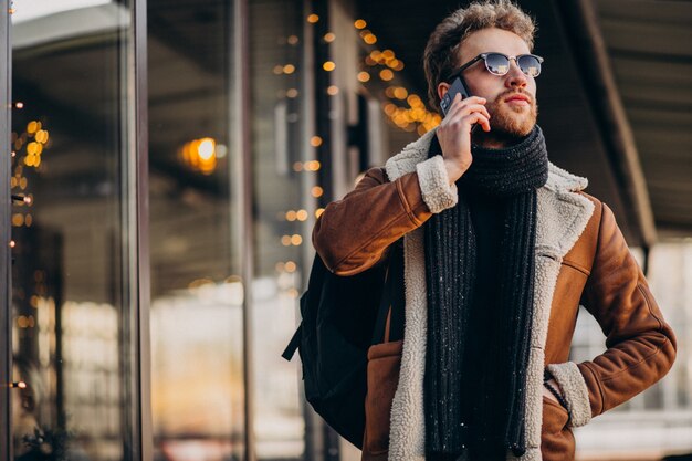 Young handsome man talking on phone by the airport