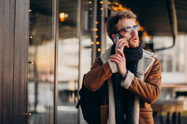 Young handsome man talking on phone by the airport