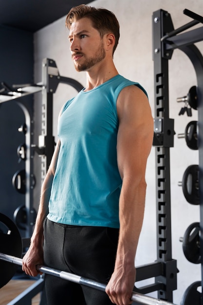 Young handsome man training at the gym for bodybuilding