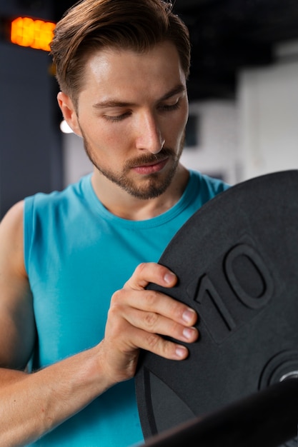 Young handsome man training at the gym for bodybuilding