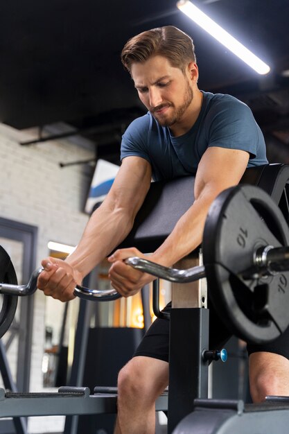 Young handsome man training at the gym for bodybuilding