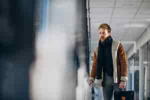 Free photo young handsome man travelling with bag