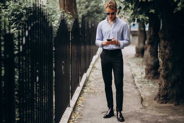 Free photo young handsome man using phone out in the street