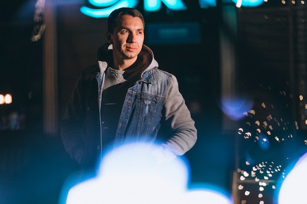 Young handsome man walking at evening outside the street