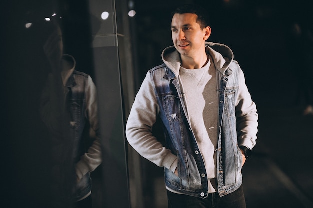 Young handsome man walking at evening outside the street