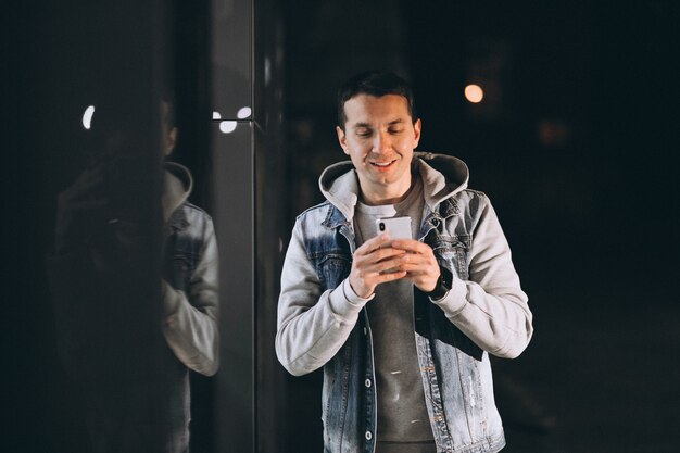 Young handsome man walking at evening outside the street