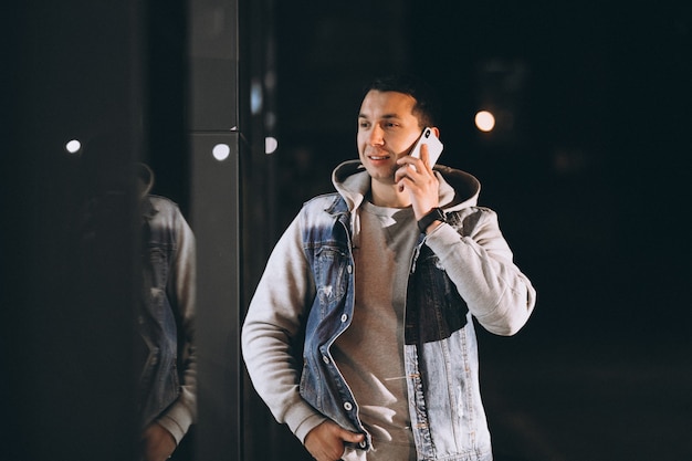 Young handsome man walking at evening outside the street