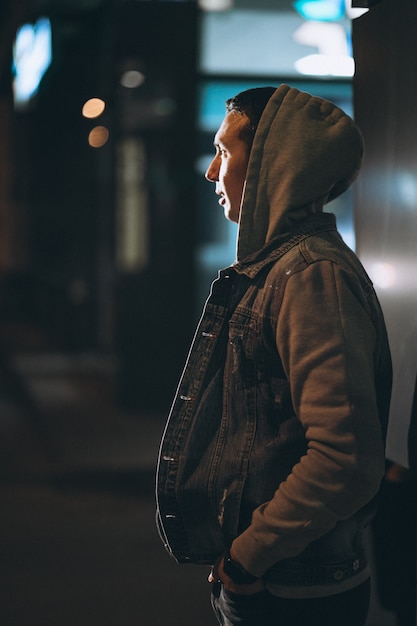 Free photo young handsome man walking at evening outside the street