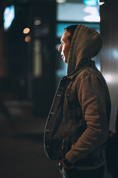 Young handsome man walking at evening outside the street