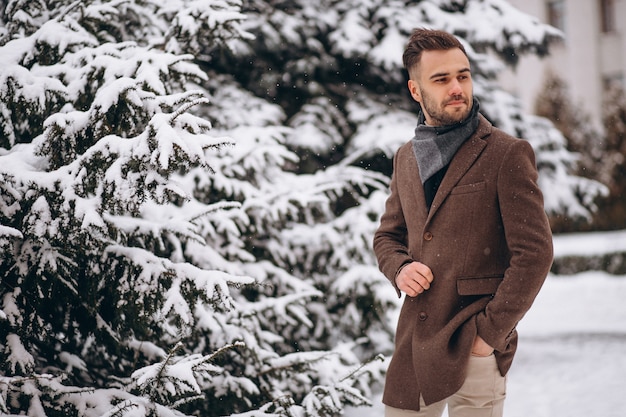 Free Photo young handsome man walking in a winter forest