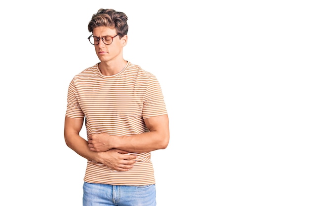 Free photo young handsome man wearing casual clothes and glasses with hand on stomach because indigestion painful illness feeling unwell ache concept