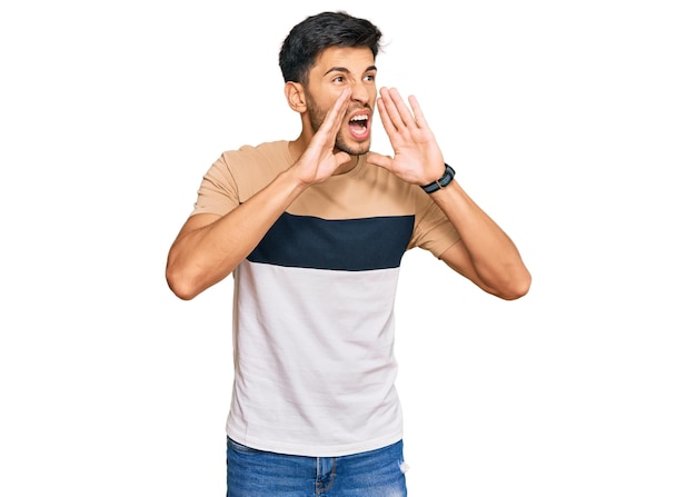 Free photo young handsome man wearing casual clothes shouting angry out loud with hands over mouth